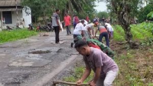 Babinsa Serda Eko Ajak Warga Timbun Lubang Jalan Membahayakan Pengendara Motor